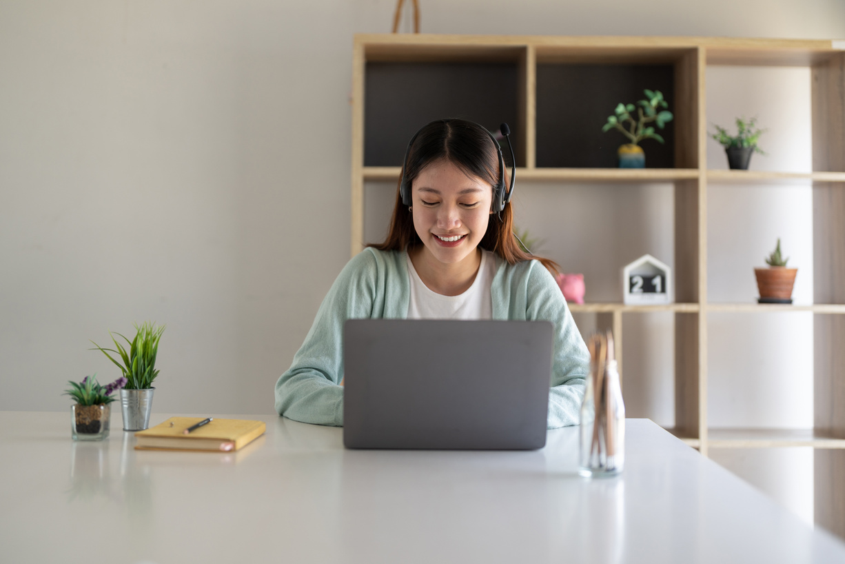 Happy young woman studying online, watching webinar, podcast